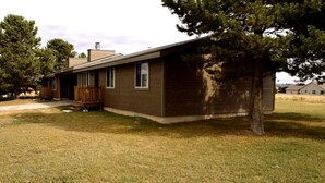 A single-story house with a front porch, a small attached garage, and a well-maintained lawn. - Paintbrush Grande - spacious & comfortable, perfect for families (West Yellowstone)