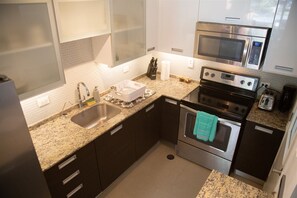 Fridge, microwave, coffee/tea maker, cookware/dishes/utensils