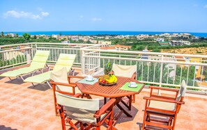 Eine Terrasse mit Tisch, Stühlen und einer Obstschale.