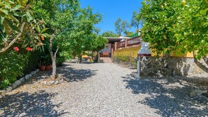A gravel pathway leading to a building with a stone wall and potted plants. - La Recacha Órgiva by Ruralidays (Granada)