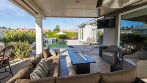 An outdoor patio with a pool, seating area, and a ceiling fan. - FONDA RETREAT VRBO 3 (Palm Desert)