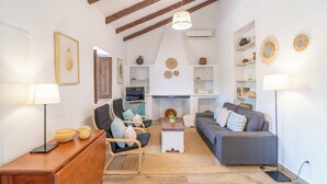 A cozy living room with a sofa, chairs, a coffee table, and a fireplace.