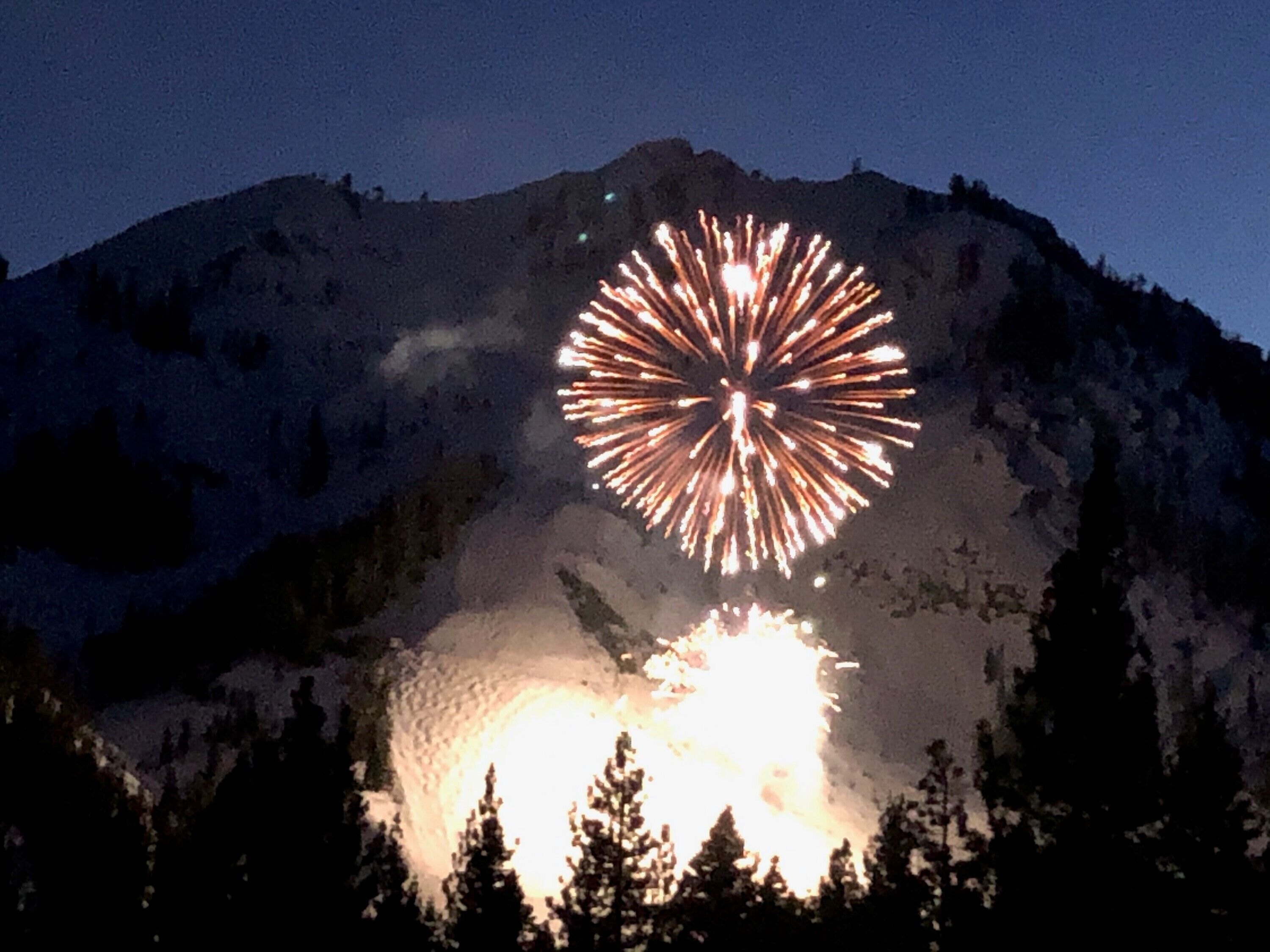 Une montagne illuminée par un feu d'artifice.