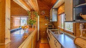 Een kleine keuken met houten wanden, een ingebouwde gootsteen en een raam dat natuurlijk licht biedt.