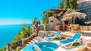A pool area with lounge chairs, a hot tub, and a waterfall feature. - Ventanas al Mediterráneo Nerja by Ruralidays (Málaga)