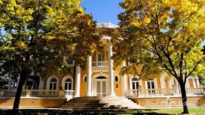Ein historisches Gebäude mit einer zentralen Kuppel, einer symmetrischen Fassade und einem prachtvollen Eingang.