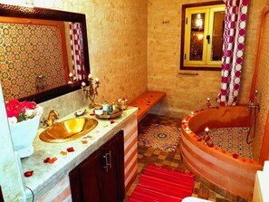 A bathroom with a large sink, a bathtub, and a window with curtains. - Riad Konouz (Marrakech)