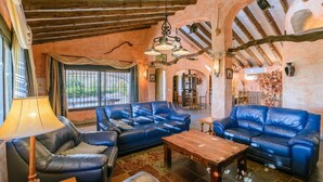 A cozy living room with leather sofas, a wooden coffee table, and a lamp. - Finca Higueron Cómpeta by Ruralidays (Málaga)