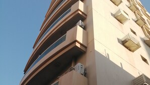 A modern building with multiple balconies and large windows.