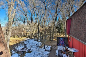 A backyard with a red shed, a brick wall, and a snow-covered ground. - Cozy Mountain Studio By Main Street & Hot Springs! (Buena Vista)