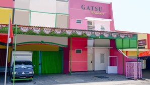 Ein farbenfrohes Gebäude mit einem Schild, auf dem 'GATSU Residence' steht.