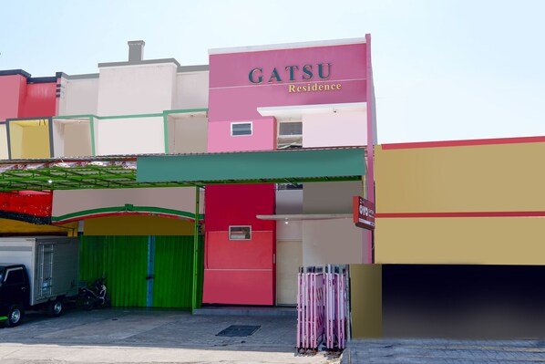 Un edificio de varios pisos con un letrero que dice "GATSU Residence".