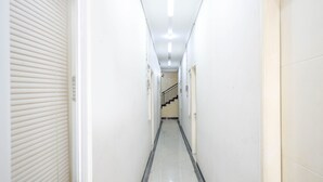 Ein schmaler, gut beleuchteter Gang mit Fliesenboden und einer Treppe am Ende.