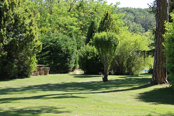 A park with a grassy area, trees, and stone structures.
