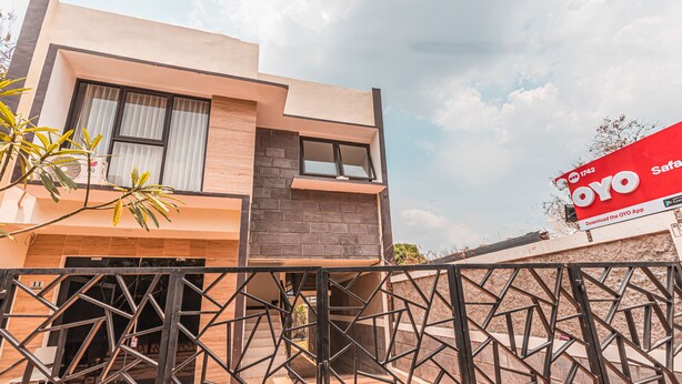 A modern two-story building with a geometric metal gate in the foreground. - OYO 1742 Safa Alya (Bekasi)