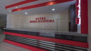 Ein Hotelrezeptionsschalter mit modernem Design, mit einem gut sichtbaren Namen und einer Treppe, die in die oberen Stockwerke führt.