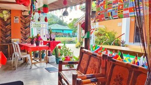 Un espacio al aire libre con mobiliario de madera y plantas en macetas.