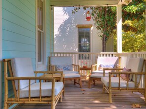 Relax on the porch with comfortable wicker chairs and a small table.