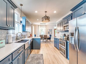 Enjoy cooking in this well-equipped kitchen with a central island, sink, microwave, and range hood.