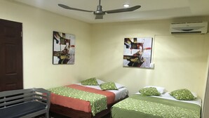 Habitación de hotel con dos camas individuales, un banco y dos cuadros abstractos en las paredes.