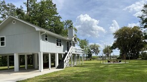 A white building with a covered porch and a staircase leading to the entrance.