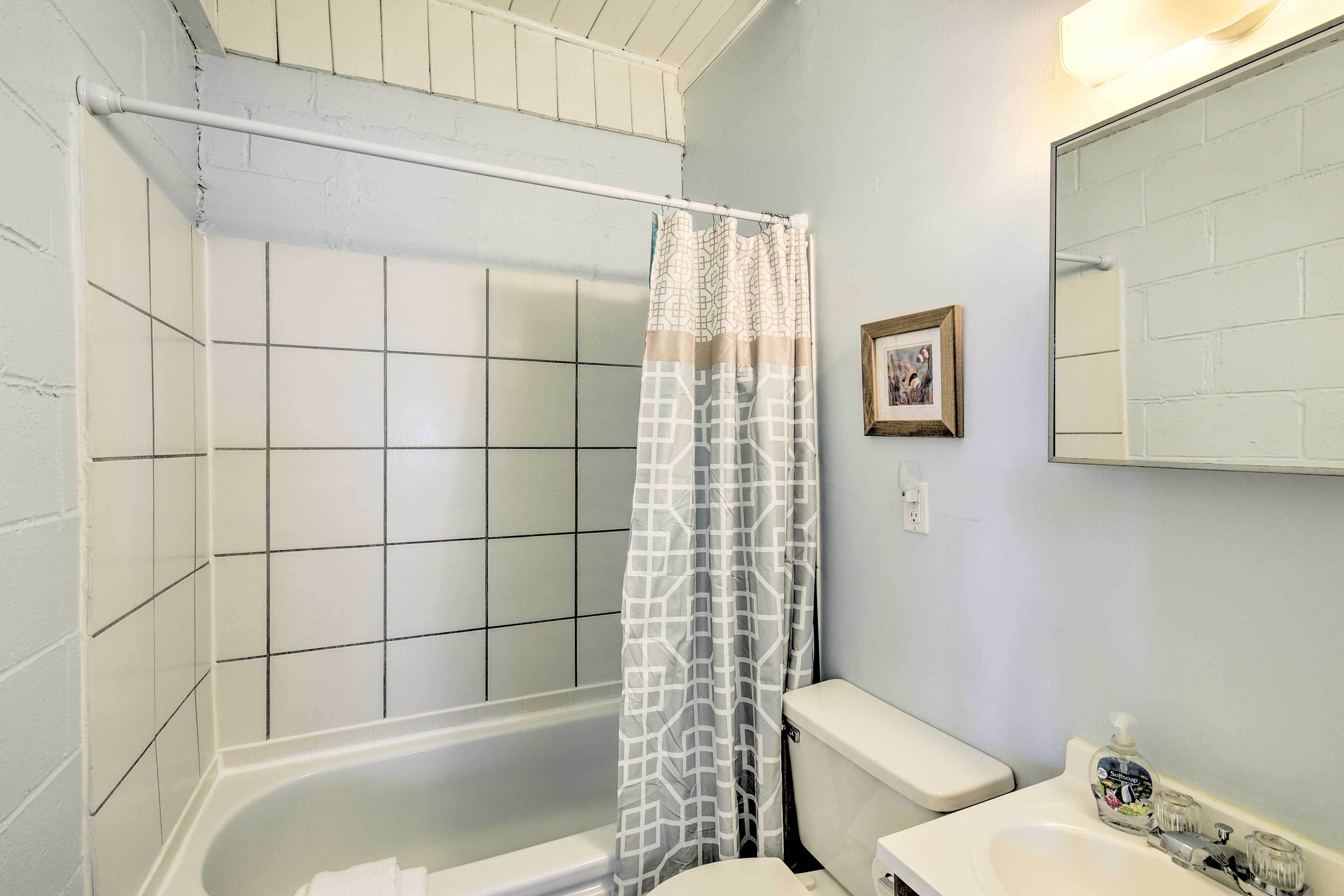 A bathroom with a bathtub, toilet, and sink.