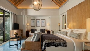 Une chambre moderne avec un grand lit, une télévision et un coin repas comprenant une table et des chaises.