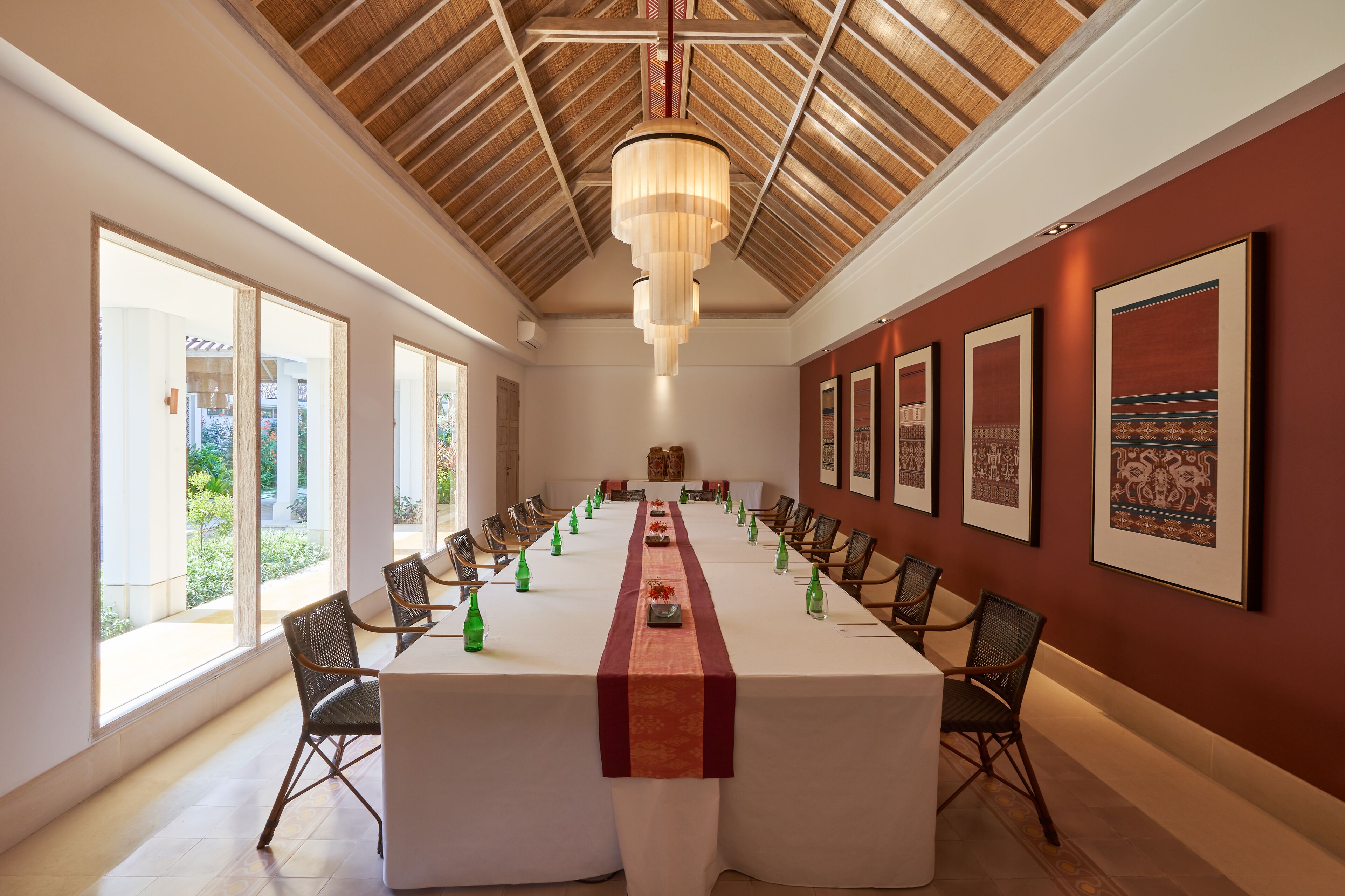 A conference room with a long table, chairs, and framed artwork on the walls.