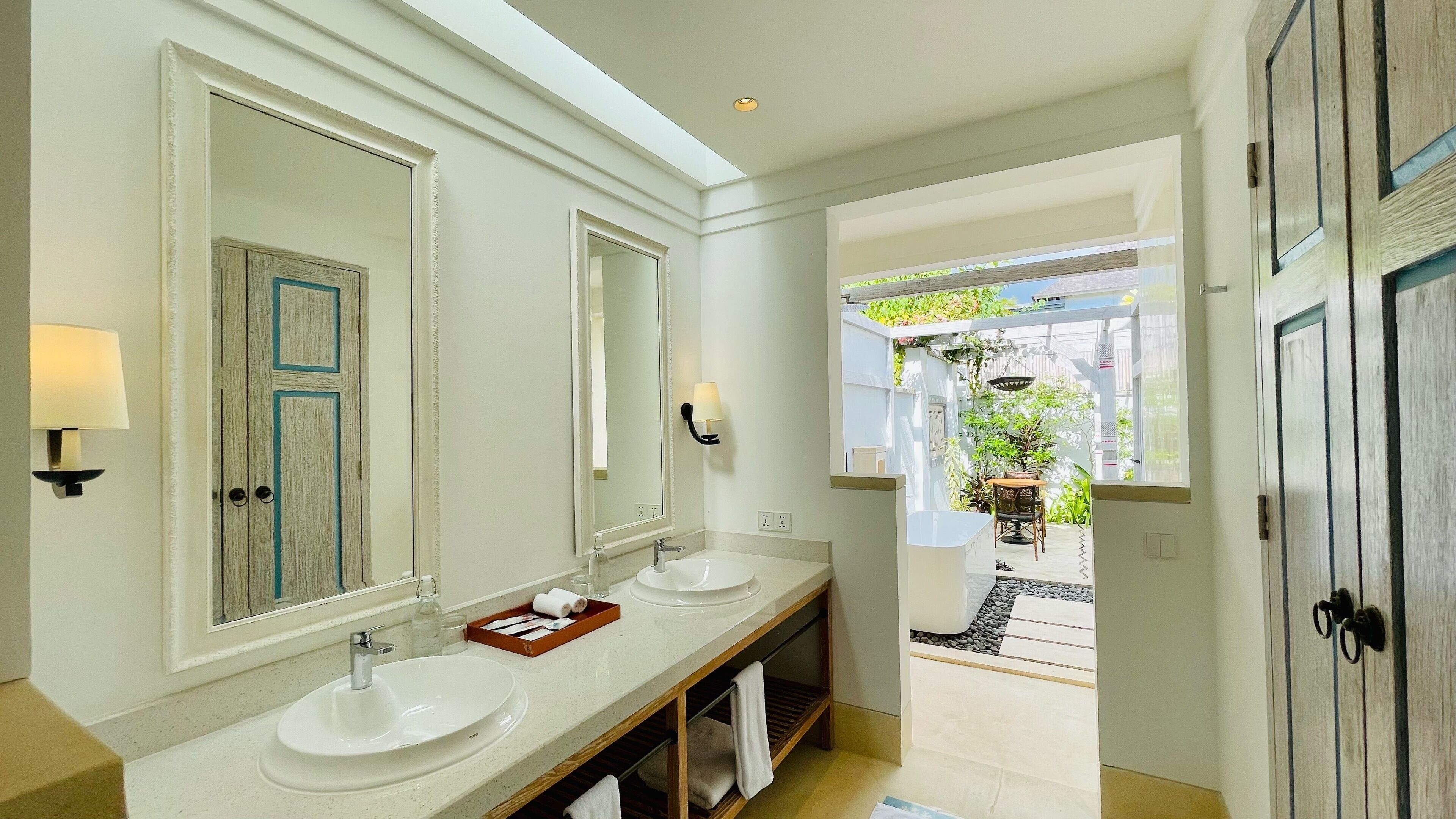 A bathroom with two sinks, a large mirror, and a vanity with a towel rack.