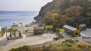 A coastal property with modern buildings, a paved driveway, and a view of the sea. - Lim Sea Side Poolvilla Pension (Namhae)
