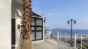 A modern building with a large window and a view of the sea. - Lim Sea Side Poolvilla Pension (Namhae)