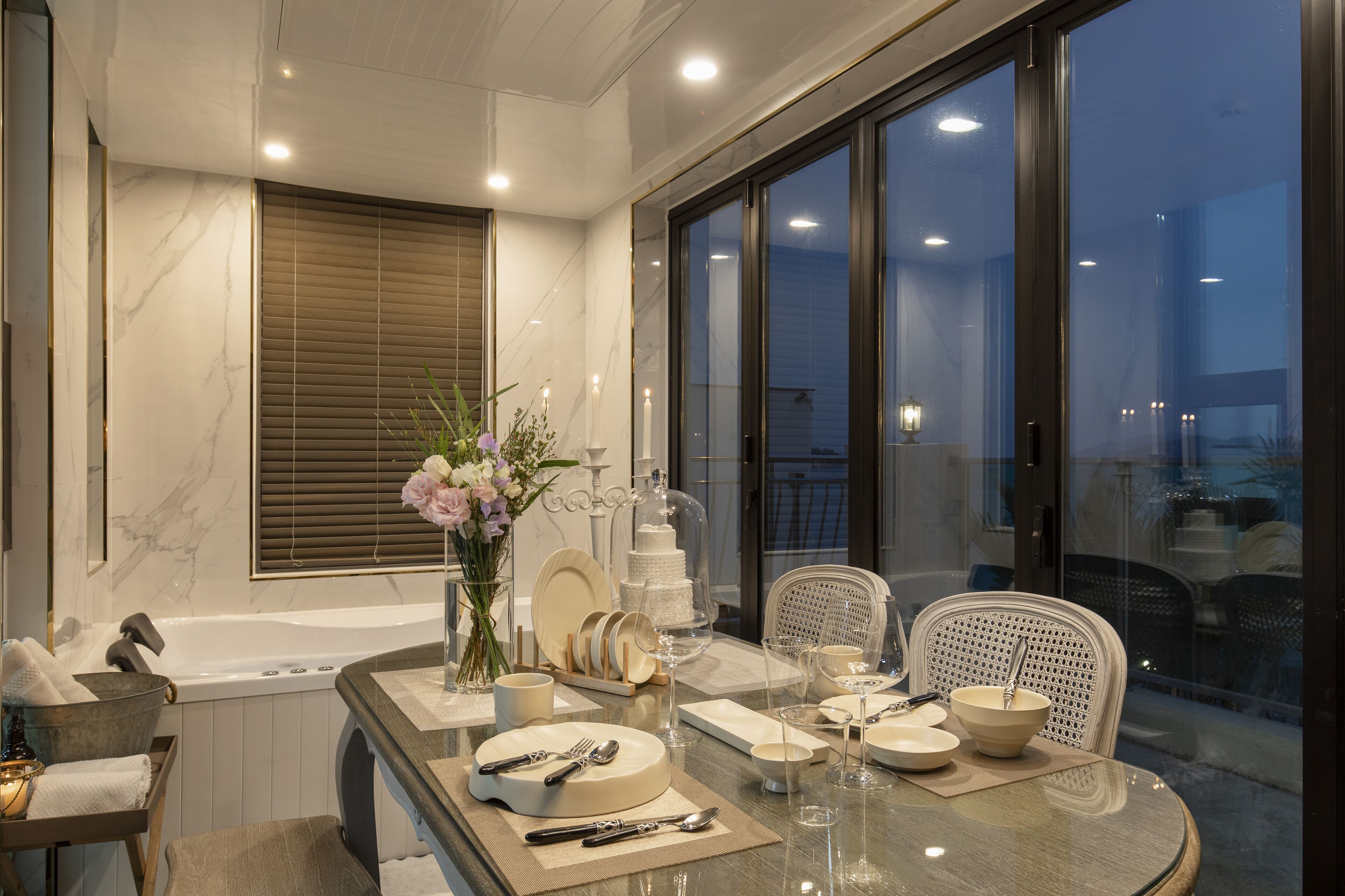 Un comedor con una mesa dispuesta para cuatro, una bañera y vistas al exterior.