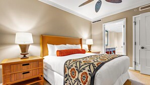 Una camera d'albergo con un letto, comodini, uno specchio e una porta.
