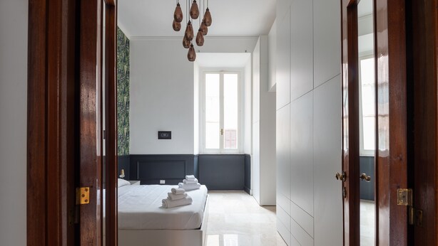 A bedroom with a bed, a window, and a door. - SPANISH STEPS 3 BEDROOM PRESTIGIOUS HOME (Roma)