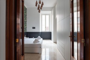 A bedroom with a bed, a window, and a door.