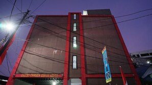 Een gebouw met een bord waarop staat 'Grand Garuda Guest House'.