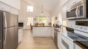 A spacious kitchen with white cabinetry, a central island, and stainless steel appliances. - Scottsdale Oasis! 5 BR, 7 beds, pool, 3000+ sq ft - near Mayo Clinic Hospital (Scottsdale)
