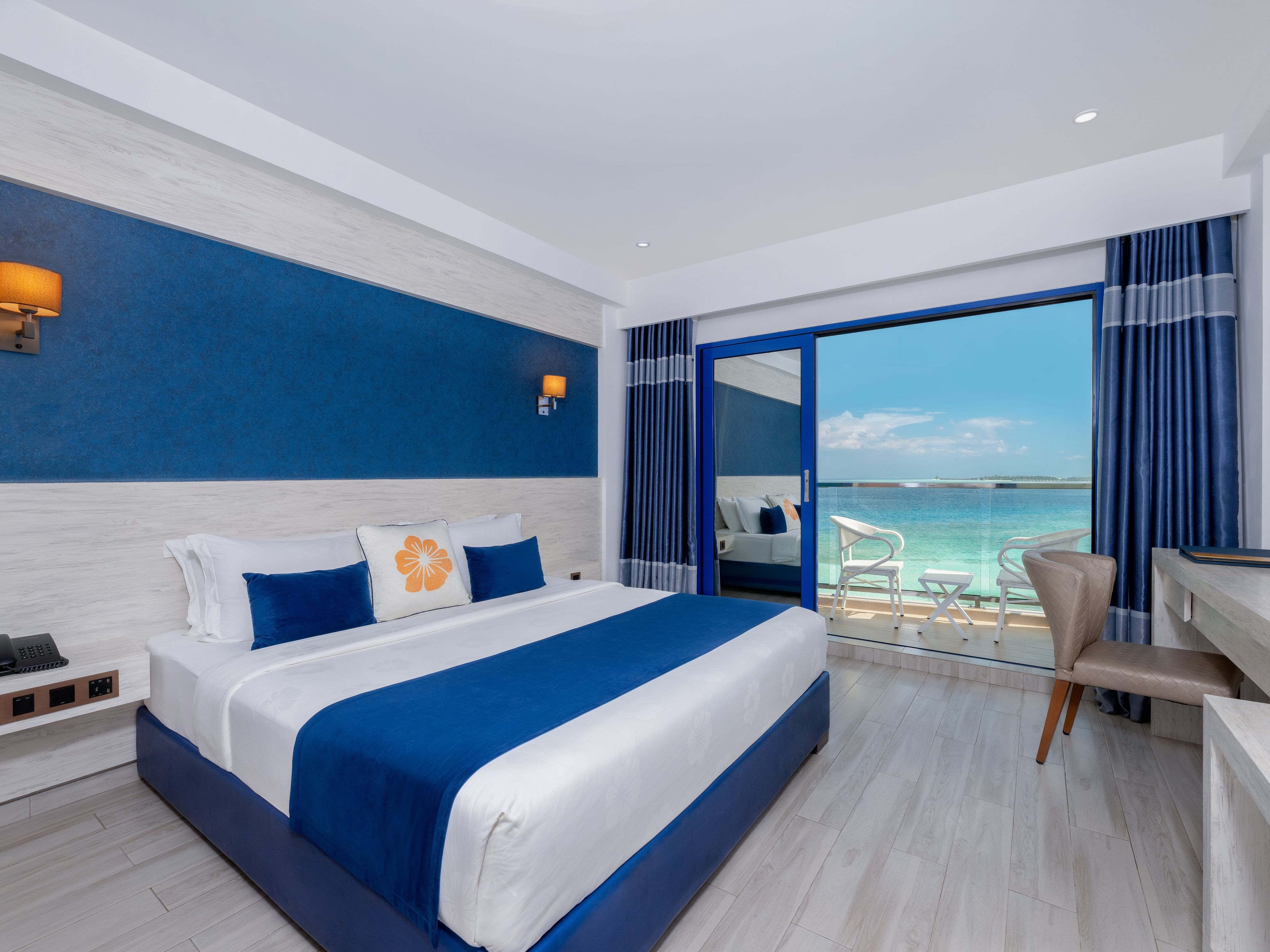 Una camera d'albergo moderna con un letto grande, una scrivania e vista mare.