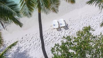 Playa privada, arena blanca, sillas reclinables de playa