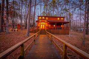 A wooden cabin with a porch and a staircase leading to the entrance.