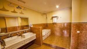 A bathroom with a double sink, a bathtub, and a shower area. - Hotel Orto-Asia (Osh)