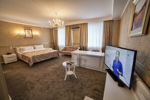 A hotel room with a bed, a desk, a television, and a small table. - Hotel Orto-Asia (Osh)