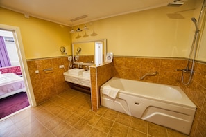 Un baño con bañera, lavamanos y ducha.
