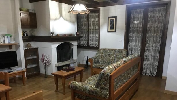 Ein Wohnzimmer mit einer Couch, einem Holztisch und einem Kamin.