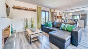 Un salon moderne avec un canapé, une table basse et une cheminée.