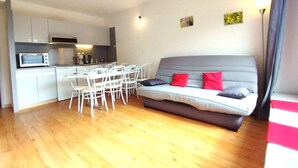 A compact living space with a kitchenette, a dining area, and a sofa.