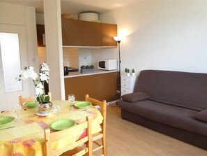 A compact living space with a dining area, kitchenette, and a sofa. - Cozy studio in Saint-Lary-Soulan with parking (Saint-Lary-Soulan)