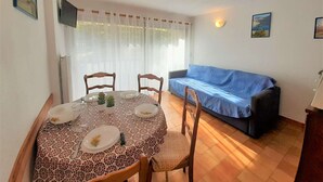 Un coin repas avec une table ronde, des chaises et un canapé bleu.