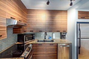 Enjoy cooking in this well-equipped kitchen with a sink, stainless steel appliances, and granite countertop.