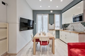 Une cuisine moderne avec des meubles blancs, un four à micro-ondes et un évier.